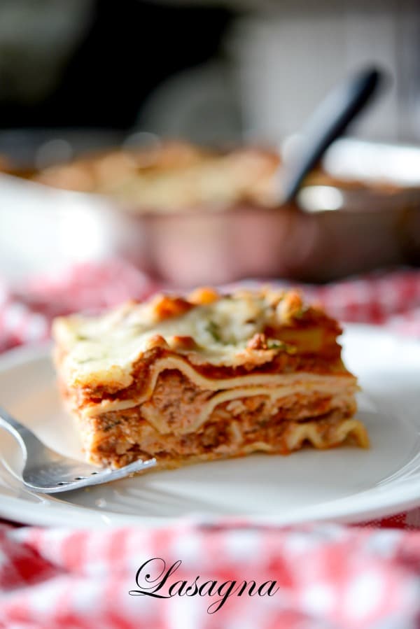 A slice of lasagna on a white plate. 