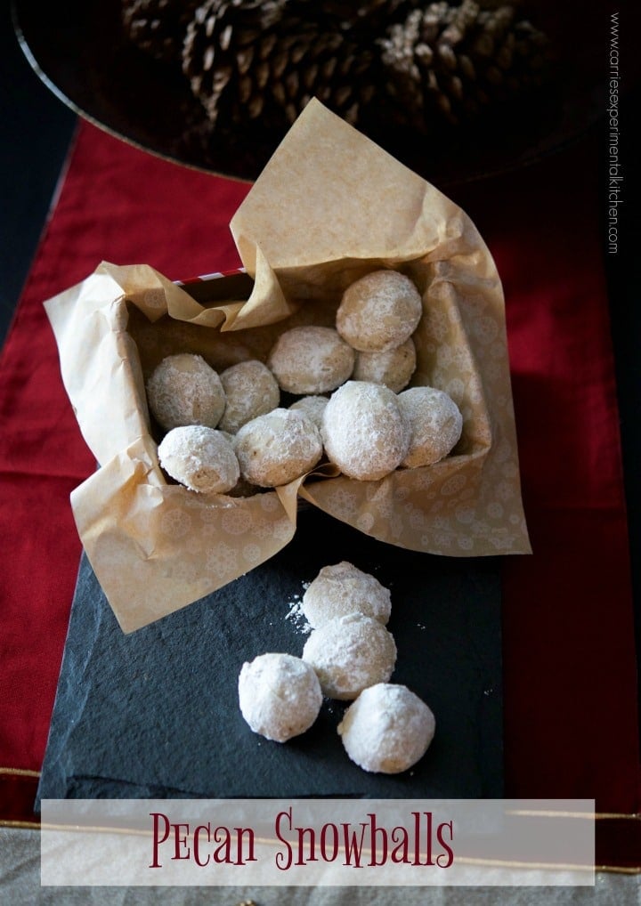 Pecan snowball cookies in parchment paper on a table. 