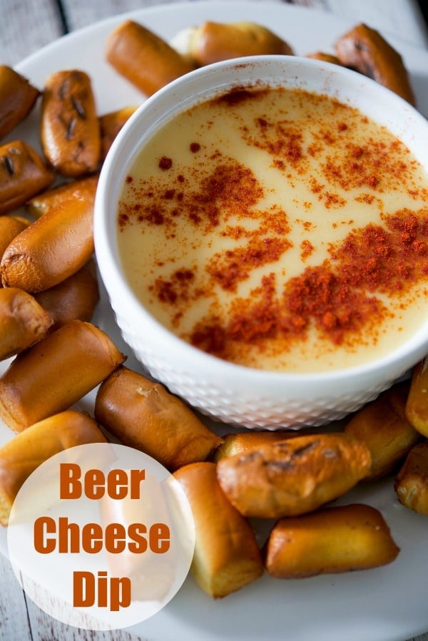 Beer Cheese Dip in a white bowl with pretzels around it. 