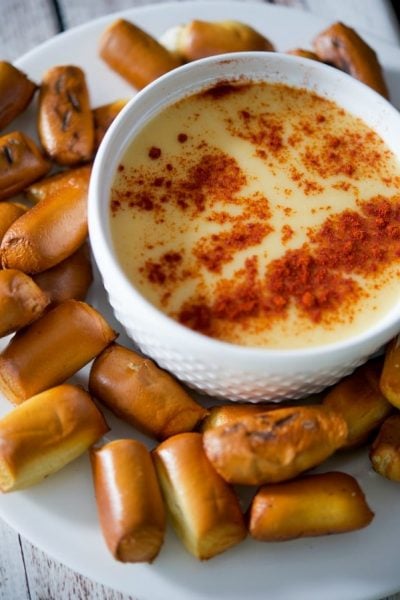 A bowl of Beer Cheese Dip with pretzels on the side.