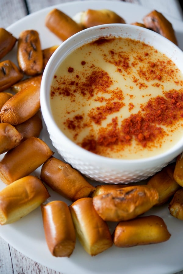 A bowl of Beer Cheese Dip with pretzels on the side. 