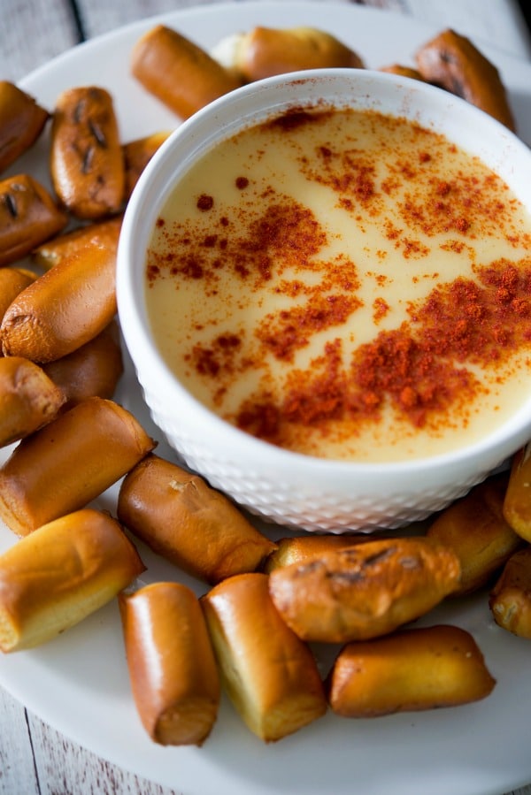 A bowl of Beer Cheese Dip with pretzels on the side. 