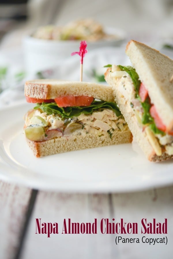 A sandwich cut in half on a plate, with Chicken and Salad