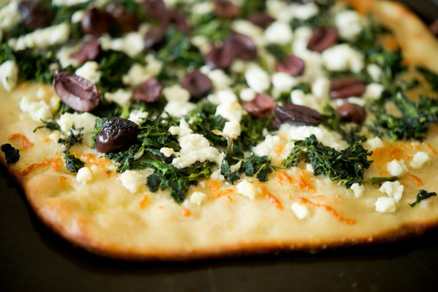 a close up of Spinach, Goat Cheese & Kalamata Olive Flatbread