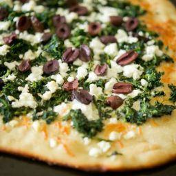 a close up of Spinach, Goat Cheese & Kalamata Olive Flatbread on a plate