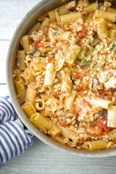 Italian Ground Chicken Pasta  in a skillet  on a wooden table.