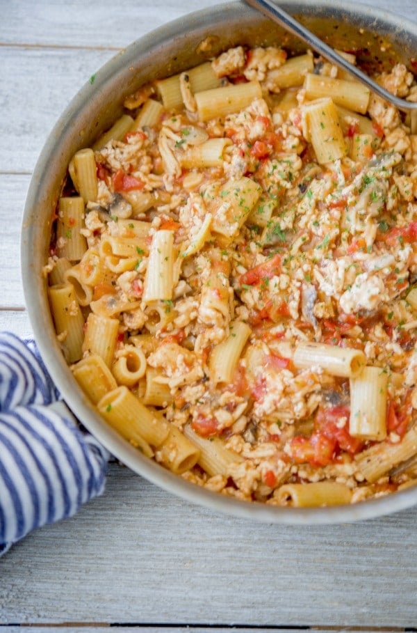 Italian Ground Chicken Pasta in a skillet with a blue and white napkin.