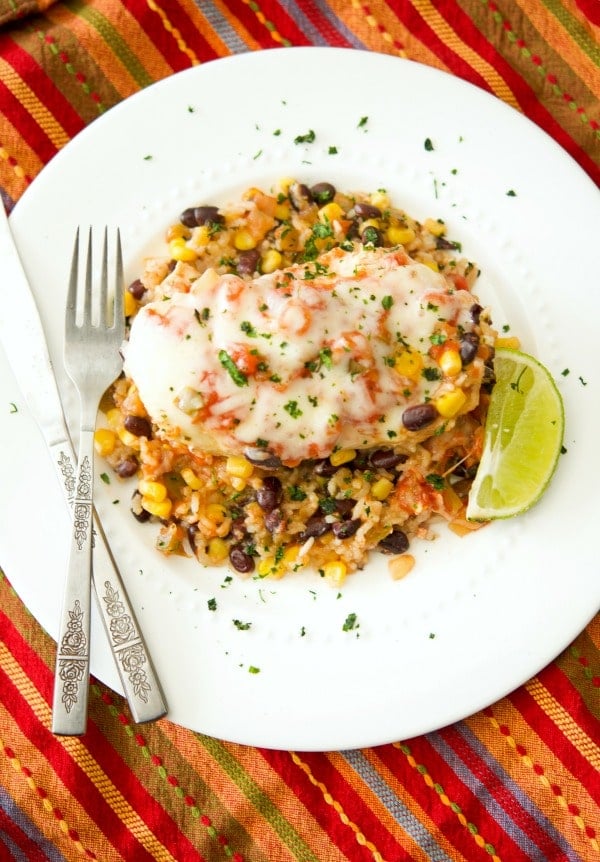Tex Mex Chicken and Rice made with black beans, corn, salsa and boneless chicken breasts on a white plate. 