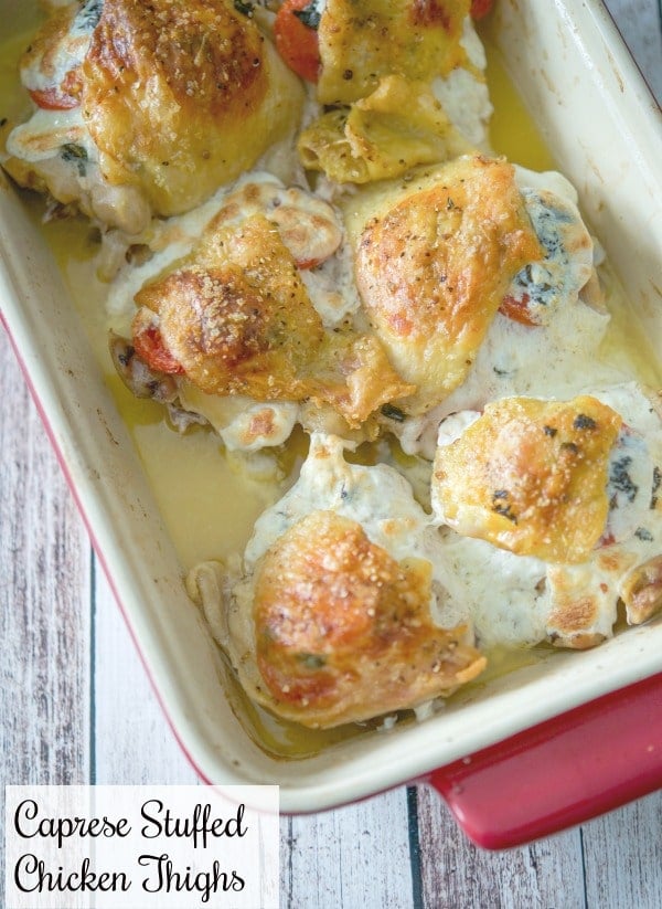 Chicken thighs stuffed with plum tomatoes, fresh Mozzarella cheese and basil in a red baking dish. 