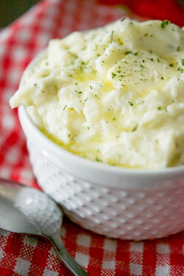 Creamy Garlic & Herb Mashed Potatoes made with Russet potatoes, Garlic & Herb Boursin Cheese, heavy cream and salted butter. 