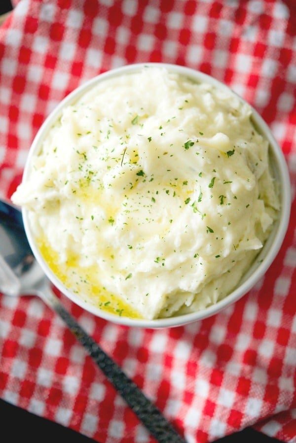 A close up of a bowl of garlic herb mashed potatoes