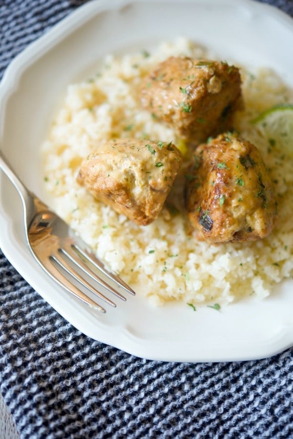 Coconut Lime Chicken Meatballs over rice on a white plate. 