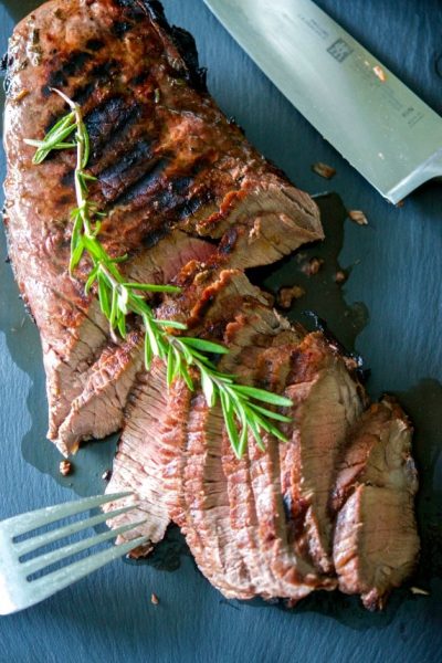 Beef London broil marinated in red wine, garlic, rosemary, balsamic vinegar and light olive oil; then grilled to your liking.