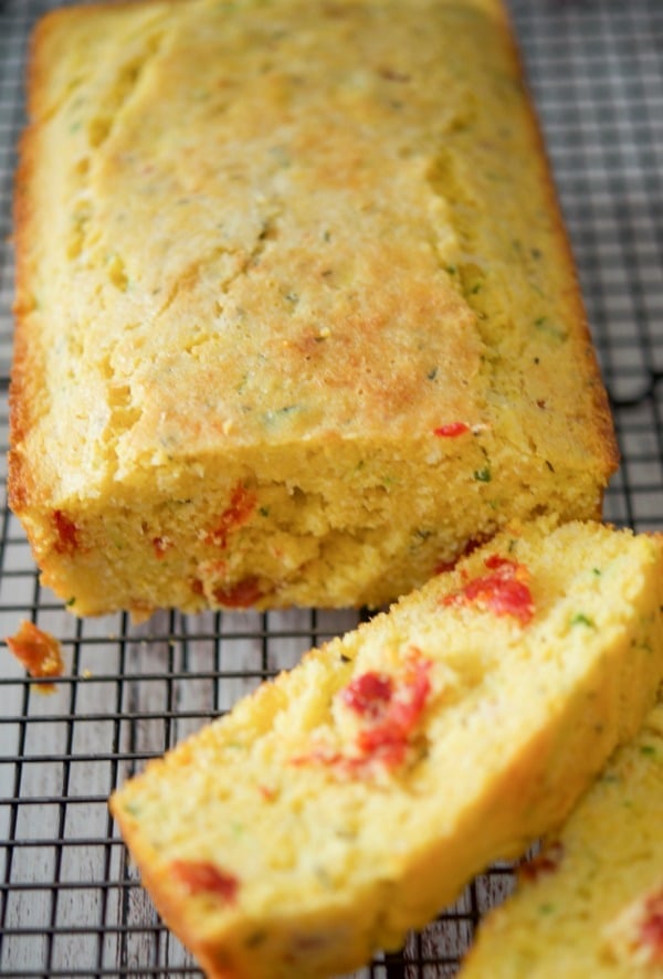 A close up of Italian Cornbread sliced on a cooling rack.