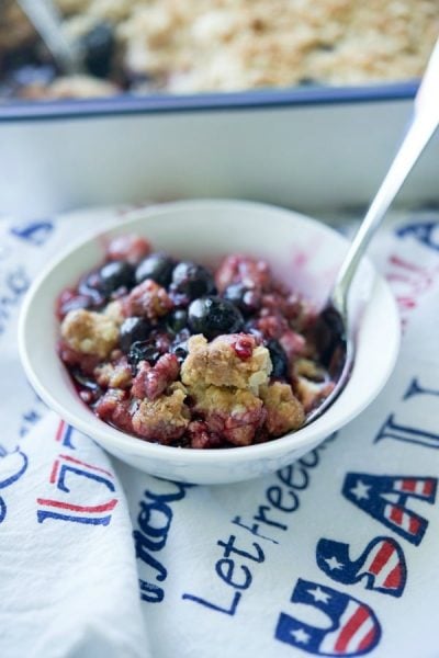 Blueberry Crisp in a white bowl with a spoon.