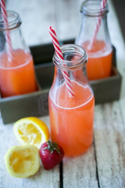 A close up of a bottle and a glass of Strawberry Lemonade