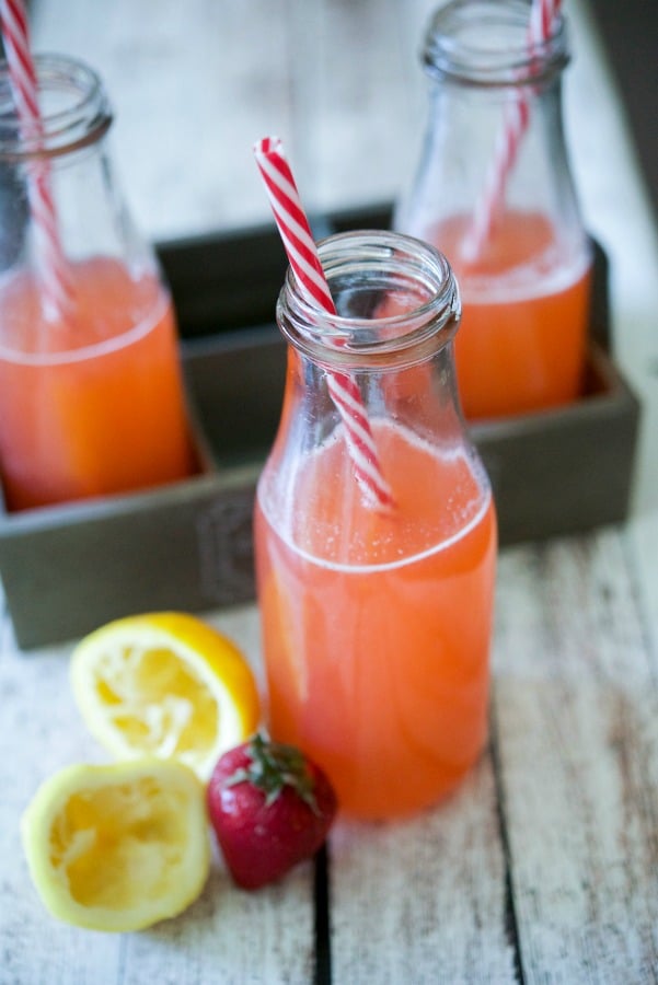 A close up of a bottle and a glass of Strawberry Lemonade