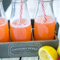 Strawberry Lemonade in a wooden crate with a lemon.
