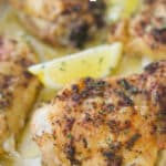 A close up of chicken thighs with lemon. 