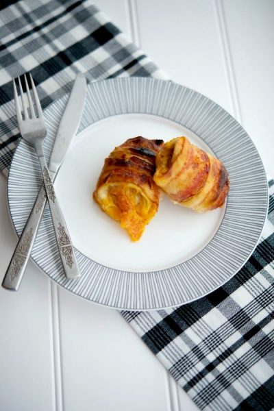 A plate of food on a table, with Bacon wrapped chicken