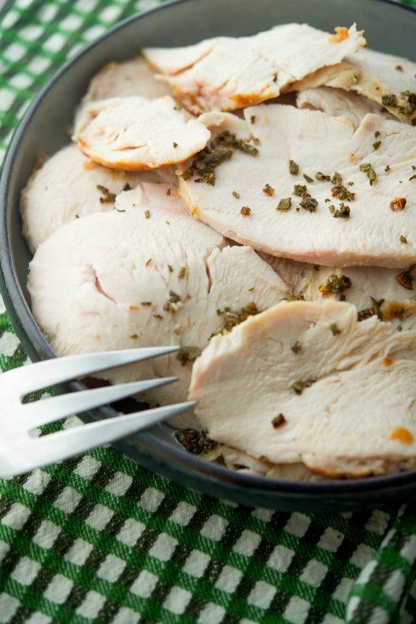 Sliced Garlic and Sage Roasted Boneless Turkey Breast on a plate with a fork. 