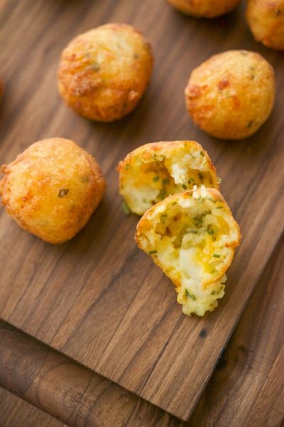 Food on a wooden cutting board, with Mashed potato puffs