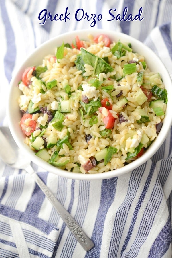 Greek Orzo Salad made with Orzo pasta, Kalamata olives, cucumbers, tomatoes, spinach and Feta cheese in a light lemon, oregano vinaigrette. 