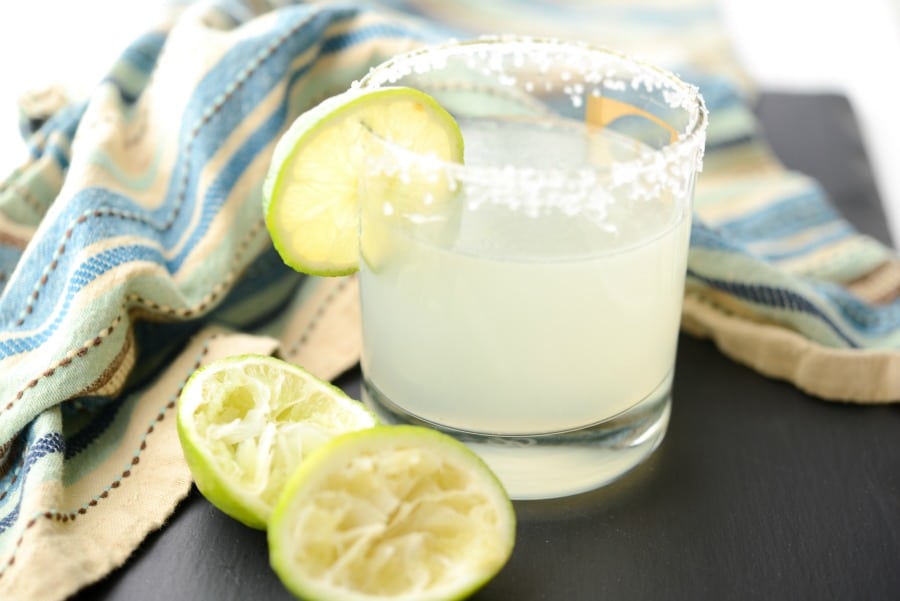 A glass of margarita with a lime