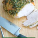 turkey breast with herbs on a wooden cutting board