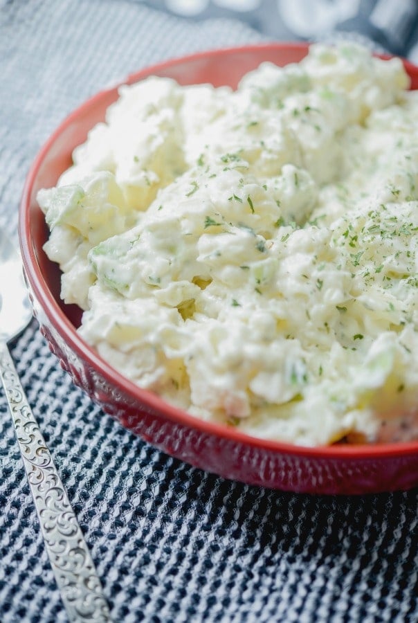 A bowl of Classic Potato Salad in a red bowl