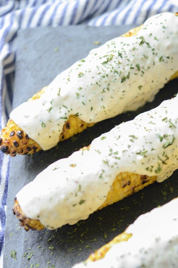 A close up of Italian Style Grilled Street Corn on a plate