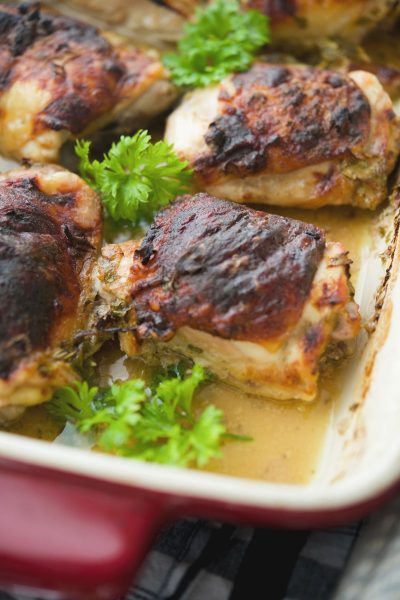 A close up of chicken thighs baked in a marinade of apple cider and Dijon mustard.