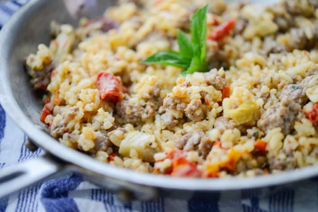 Sausage, Artichoke Hearts and Sun Dried Tomato Risotto in skillet