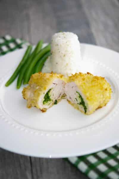 Turkey Kiev on a white plate with rice and green beans.