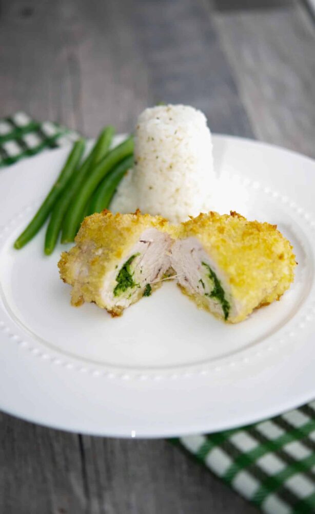 Turkey Kiev on a white plate with rice and green beans.