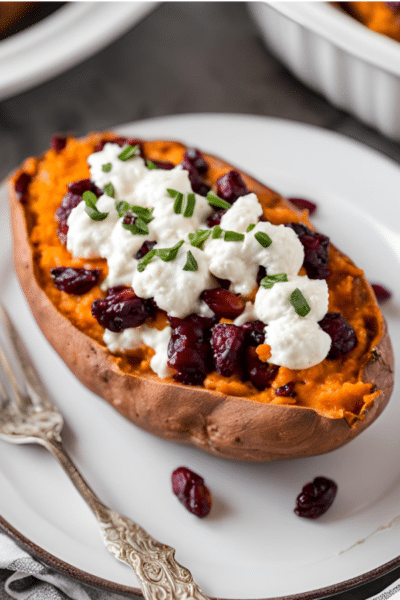 a cranberry goat cheese stuffed sweet potato on a plate