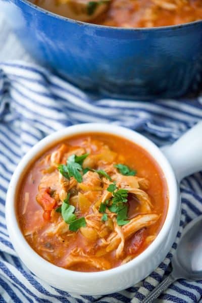 A bowl of soup with roasted chicken, fire roasted tomatoes and chick peas.