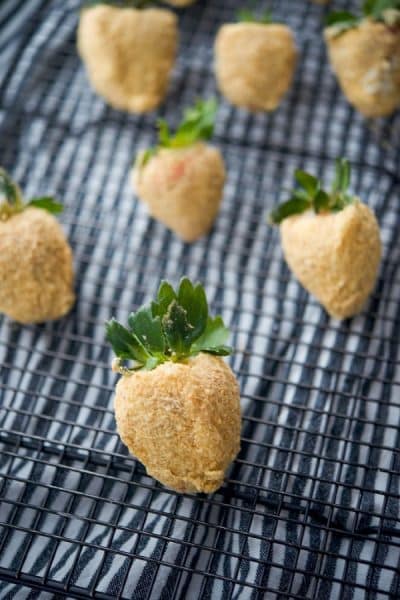 Fresh strawberries coated with sweet cream cheese icing; then dipped in graham cracker crumbs make a tasty after school or holiday treat. 