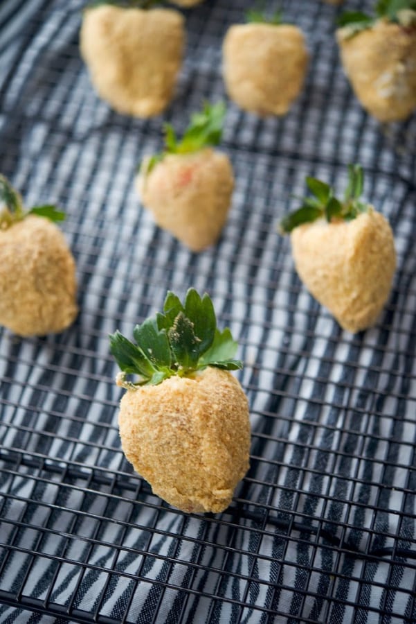 Fresh strawberries coated with sweet cream cheese icing; then dipped in graham cracker crumbs make a tasty after school snack or holiday treat. 