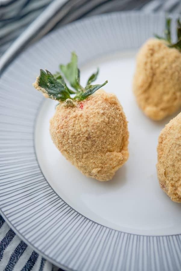Fresh strawberries coated with sweet cream cheese icing; then dipped in graham cracker crumbs make a tasty after school snack or holiday treat. 