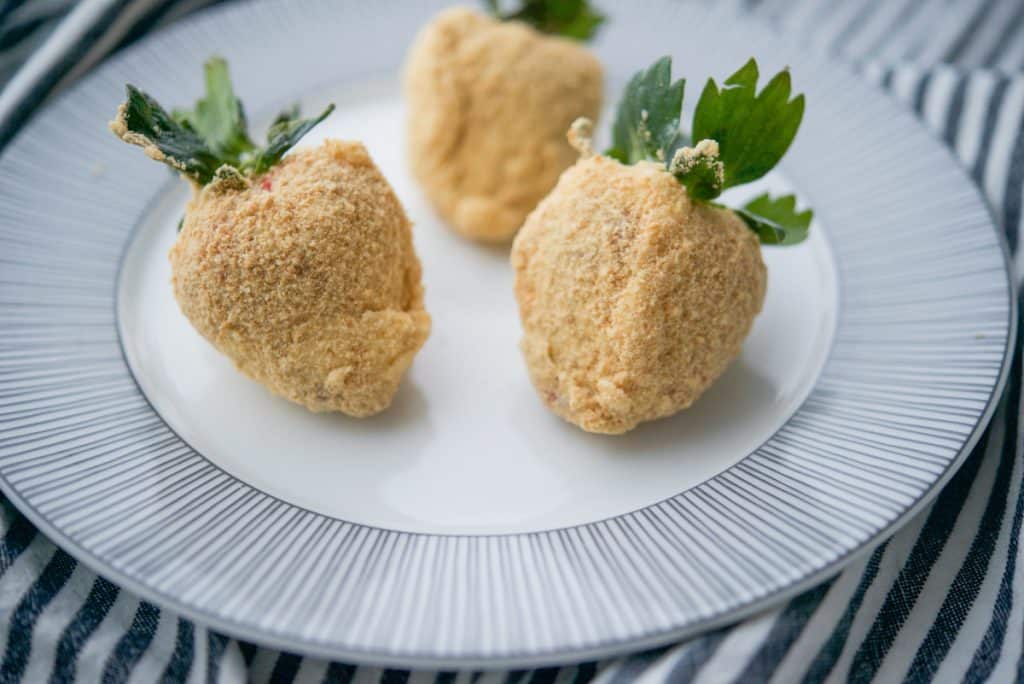 Cheesecake Coated Strawberries on white plate