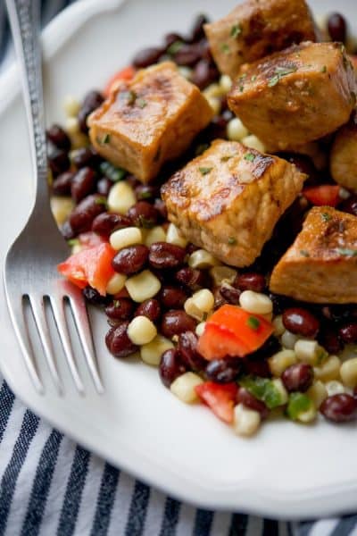 A plate of Tequila Lime Pork Bites over Black Bean Salsa