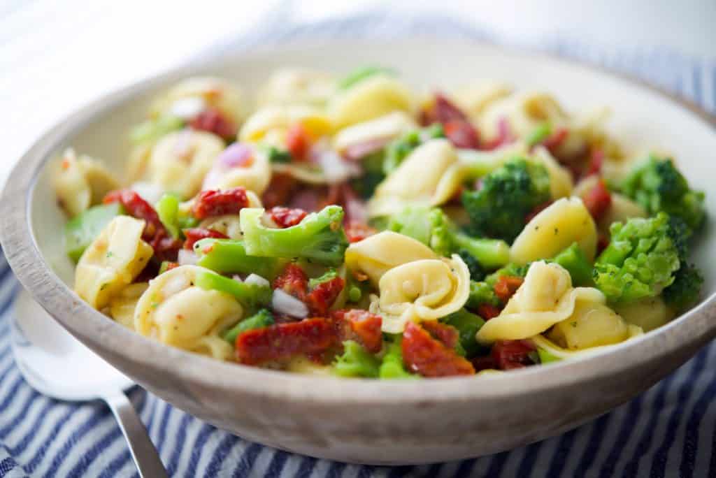 Tortellini Salad with Sun Dried Tomatoes and Broccoli in a white bowl