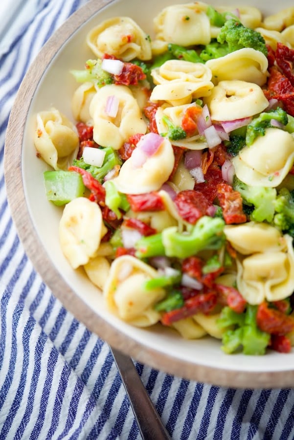 Cheese tortellini combined with fresh sun dried tomatoes, broccoli florets, and onions in a zesty Italian vinaigrette dressing is a hearty cold pasta salad that's great for get togethers. 