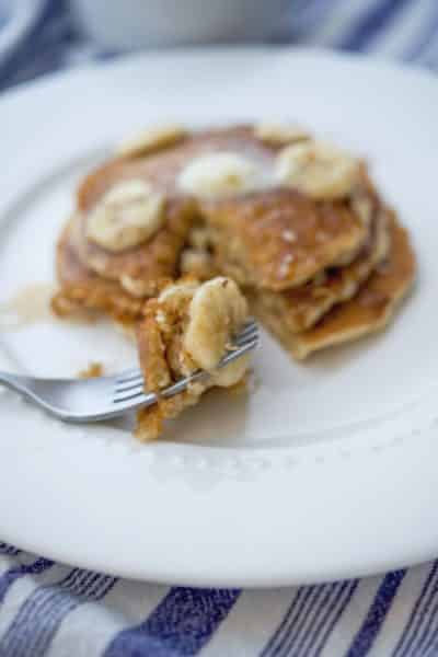 Pancakes made with rolled oats, flour, milk, eggs and fresh bananas topped with banana maple syrup is a delicious way to start the day.