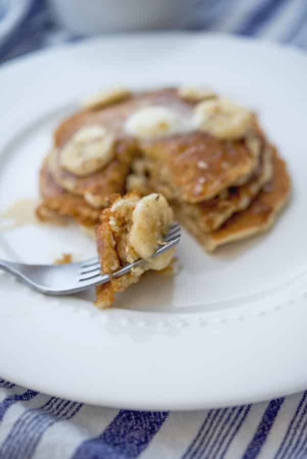 Pancakes made with rolled oats, flour, milk, eggs and fresh bananas topped with banana maple syrup is a delicious way to start the day.