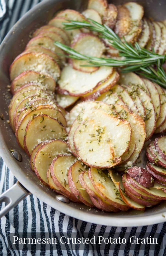 Parmesan Crusted Potato Gratin made in a skillet with layered red potatoes, butter, fresh rosemary and grated Parmesan cheese. 