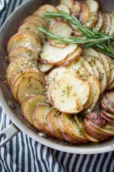 Parmesan Crusted Potato Gratin made in a skillet with layered red potatoes, butter, fresh rosemary and grated Parmesan cheese. 