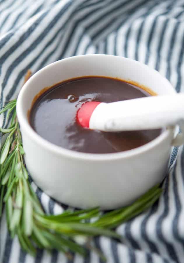 A close up of balsamic bbq sauce with a baster. 