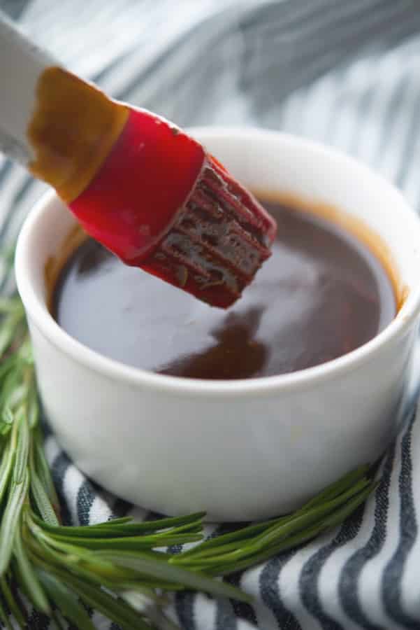 A bowl of Balsamic BBQ Sauce with a red basting brush. 